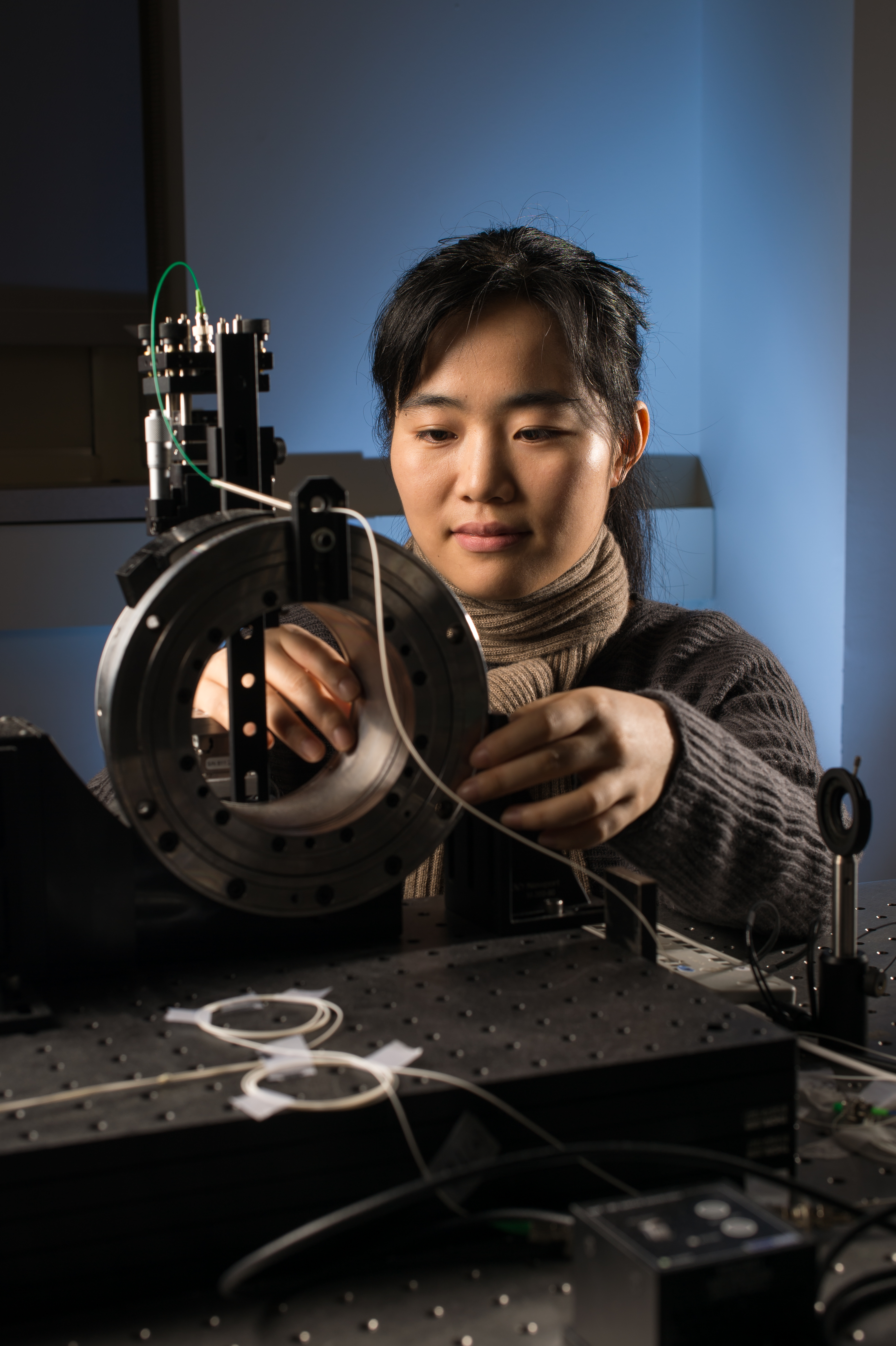 Jianing Yao, University of Rochester PhD student in Optics 2016 (undergrad: Tianjin University, China) adjusts an angular scan optical coherence tomography (OCT) system that was developed to perform 3D visualization and nondestructive testing of gradient refractive index lenses and preforms with high curvatures, during a session in her lab in Goergen Hall February 11, 2015.  The precision metrology enabled by OCT assists in guiding the evolution of the manufacturing process.  // photo by J. Adam Fenster / University of Rochester